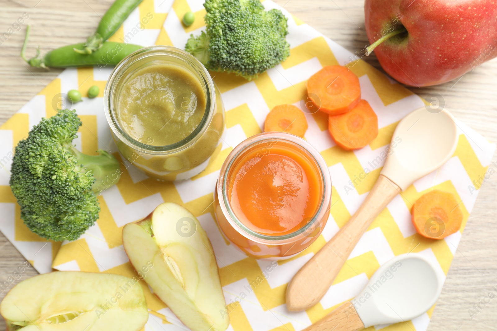 Baby food. Tasty puree in jars and ingredients on wooden table, flat lay Photo of Baby food. Tasty puree in jars and ingredients on wooden table, flat lay