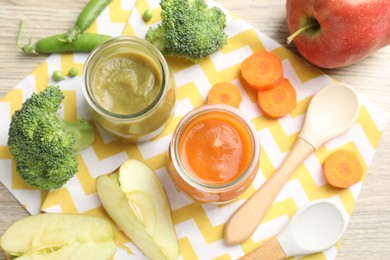 Photo of Baby food. Tasty puree in jars and ingredients on wooden table, flat lay