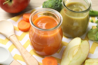 Photo of Baby food. Tasty puree in glass jars and ingredients on table, closeup