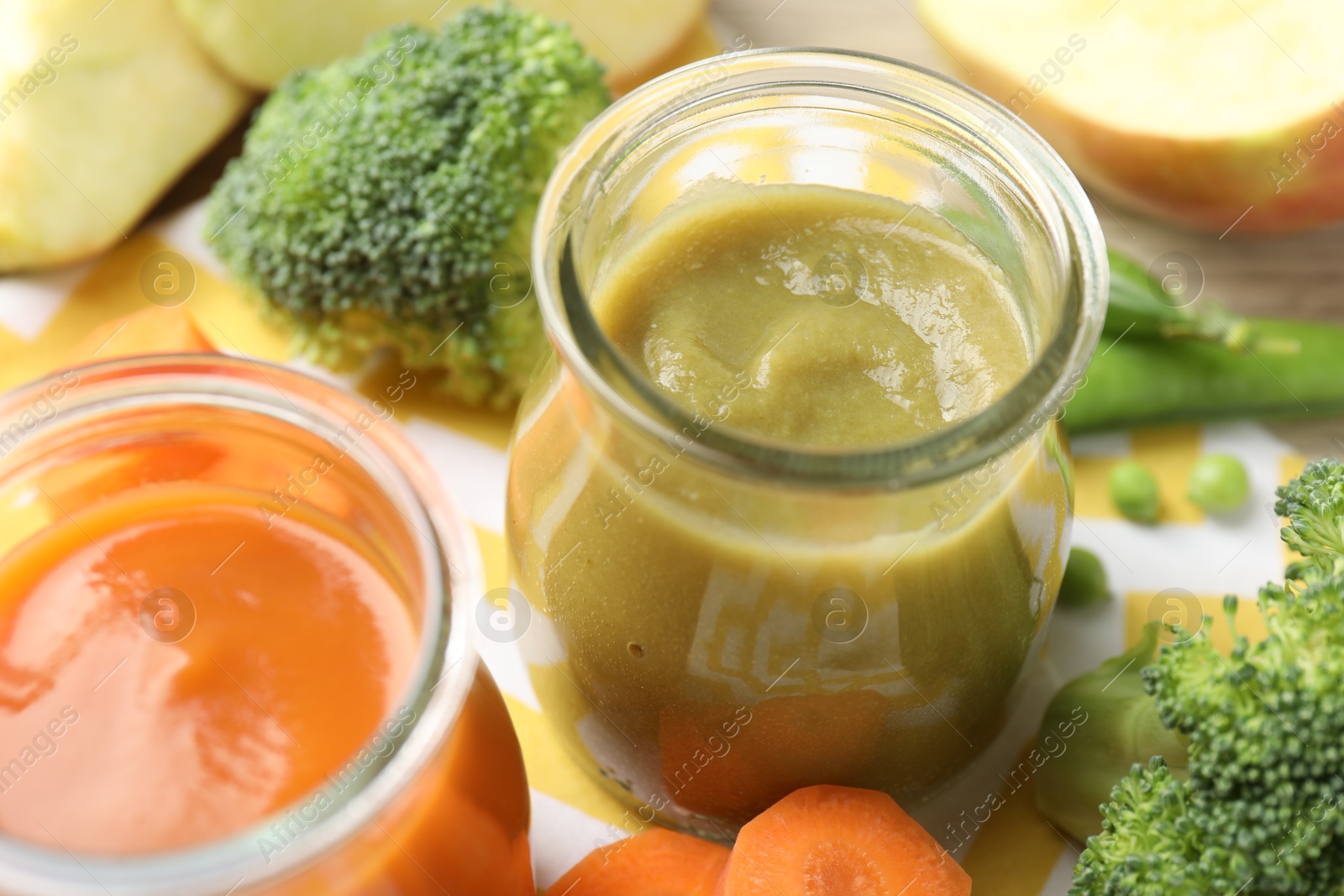 Baby food. Tasty puree in glass jars and ingredients on table, closeup Photo of Baby food. Tasty puree in glass jars and ingredients on table, closeup