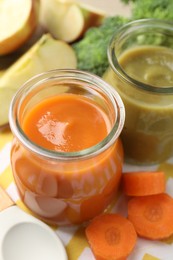Photo of Baby food. Tasty puree in glass jars and ingredients on table, closeup
