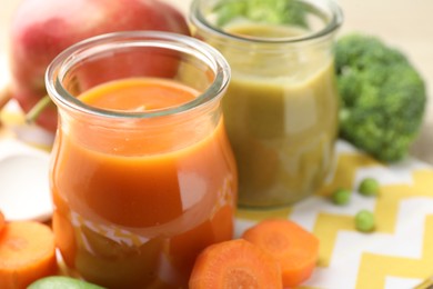 Photo of Baby food. Tasty puree in glass jars and ingredients on table, closeup. Space for text