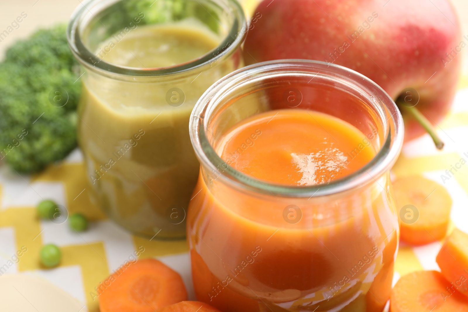 Baby food. Tasty puree in glass jars and ingredients on table, closeup Photo of Baby food. Tasty puree in glass jars and ingredients on table, closeup