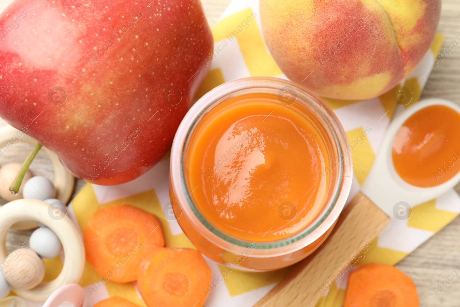 Baby food. Tasty puree in jar, ingredients and teether on table, flat lay Photo of Baby food. Tasty puree in jar, ingredients and teether on table, flat lay