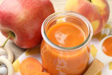 Photo of Baby food. Tasty puree in glass jar and ingredients on table, closeup