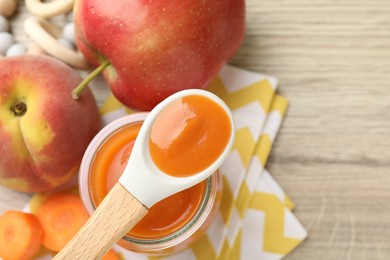 Photo of Baby food. Tasty puree in jar, ingredients and spoon on wooden table, flat lay. Space for text