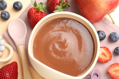 Photo of Baby food. Tasty puree in bowl, ingredients and spoon on beige background, flat lay