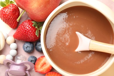 Photo of Baby food. Tasty puree in bowl, ingredients, pacifier and teether on table, flat lay
