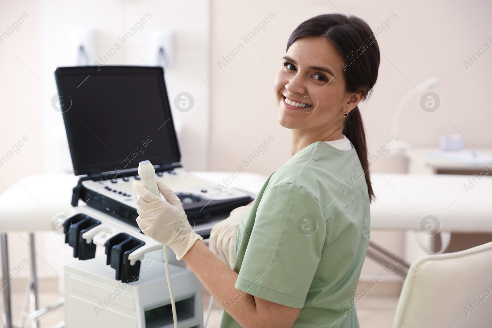 Professional sonographer with ultrasound machine in clinic Photo of Professional sonographer with ultrasound machine in clinic
