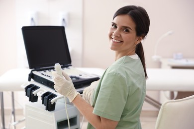 Photo of Professional sonographer with ultrasound machine in clinic