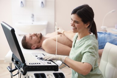 Photo of Sonographer conducting ultrasound examination of man's heart in clinic