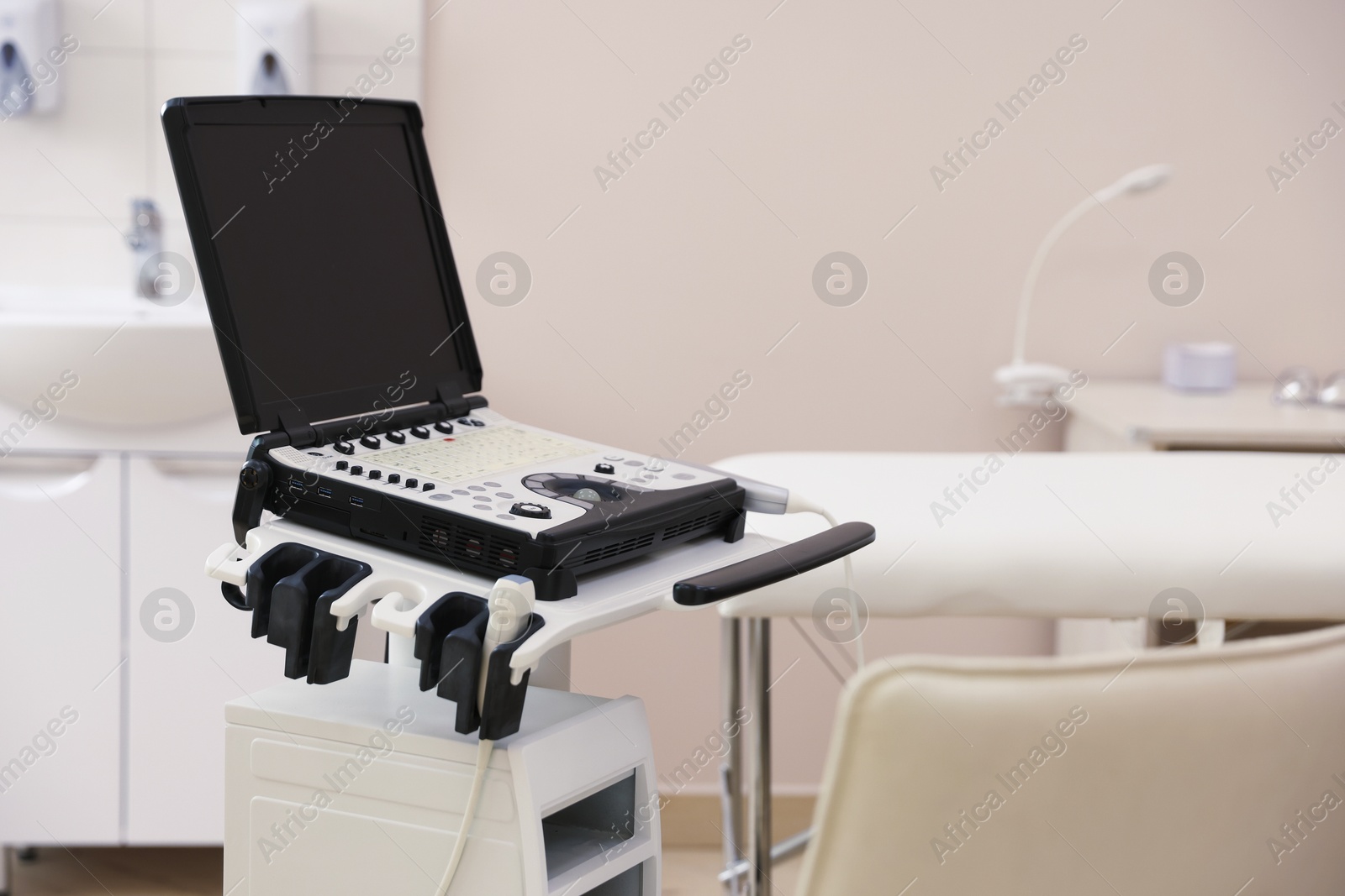 Modern ultrasound machine and examination bed in clinic Photo of Modern ultrasound machine and examination bed in clinic