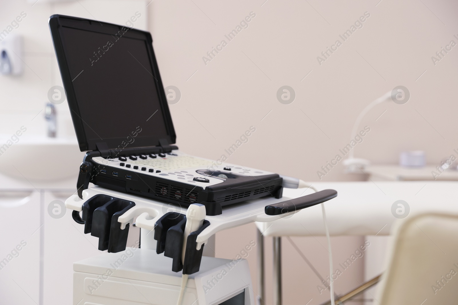 Modern ultrasound machine and examination bed in clinic Photo of Modern ultrasound machine and examination bed in clinic