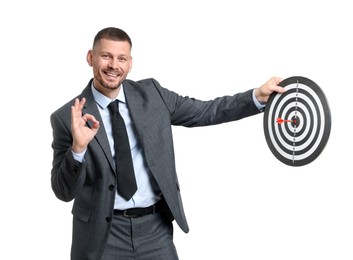 Photo of Targeting. Man with dart board and arrow showing ok gesture on white background