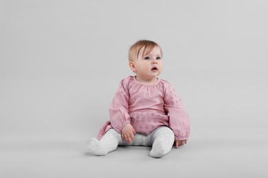 Photo of Cute little baby on light grey background