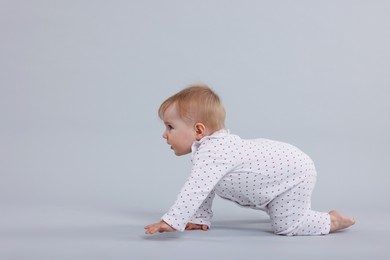 Photo of Cute little baby crawling on light grey background, space for text