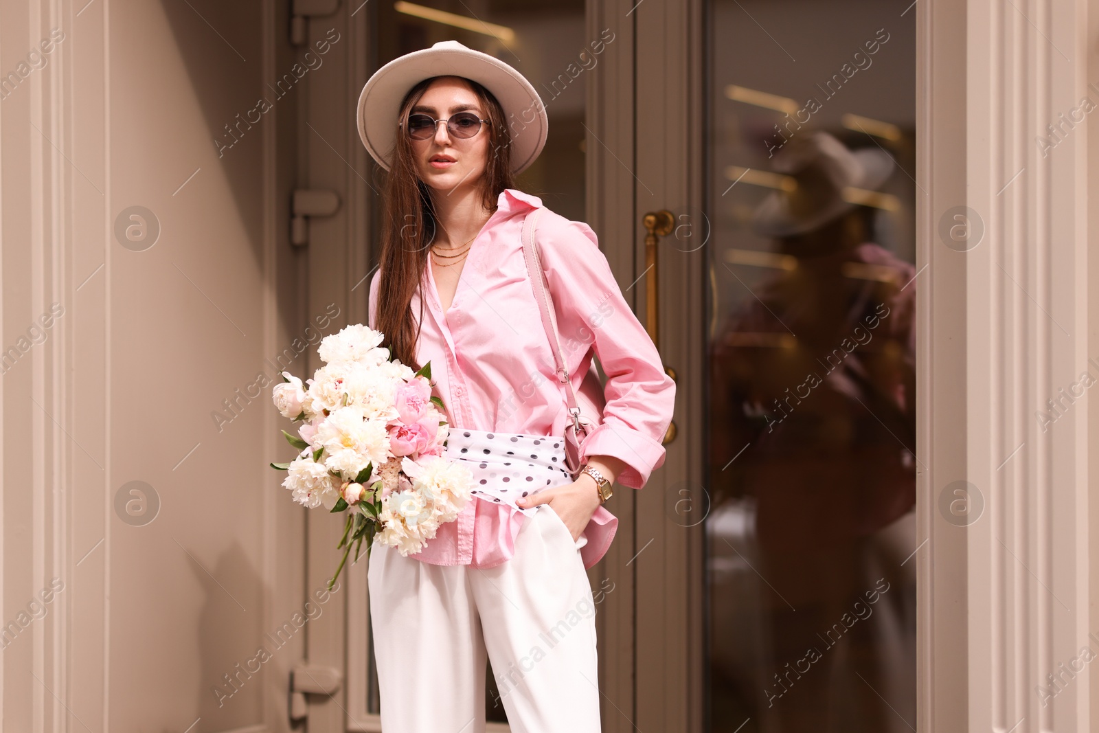 Photo of Stylish woman with bouquet of beautiful peonies outdoors