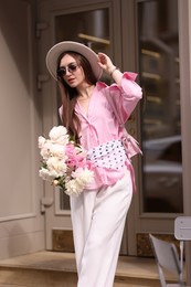 Photo of Stylish woman with bouquet of beautiful peonies outdoors