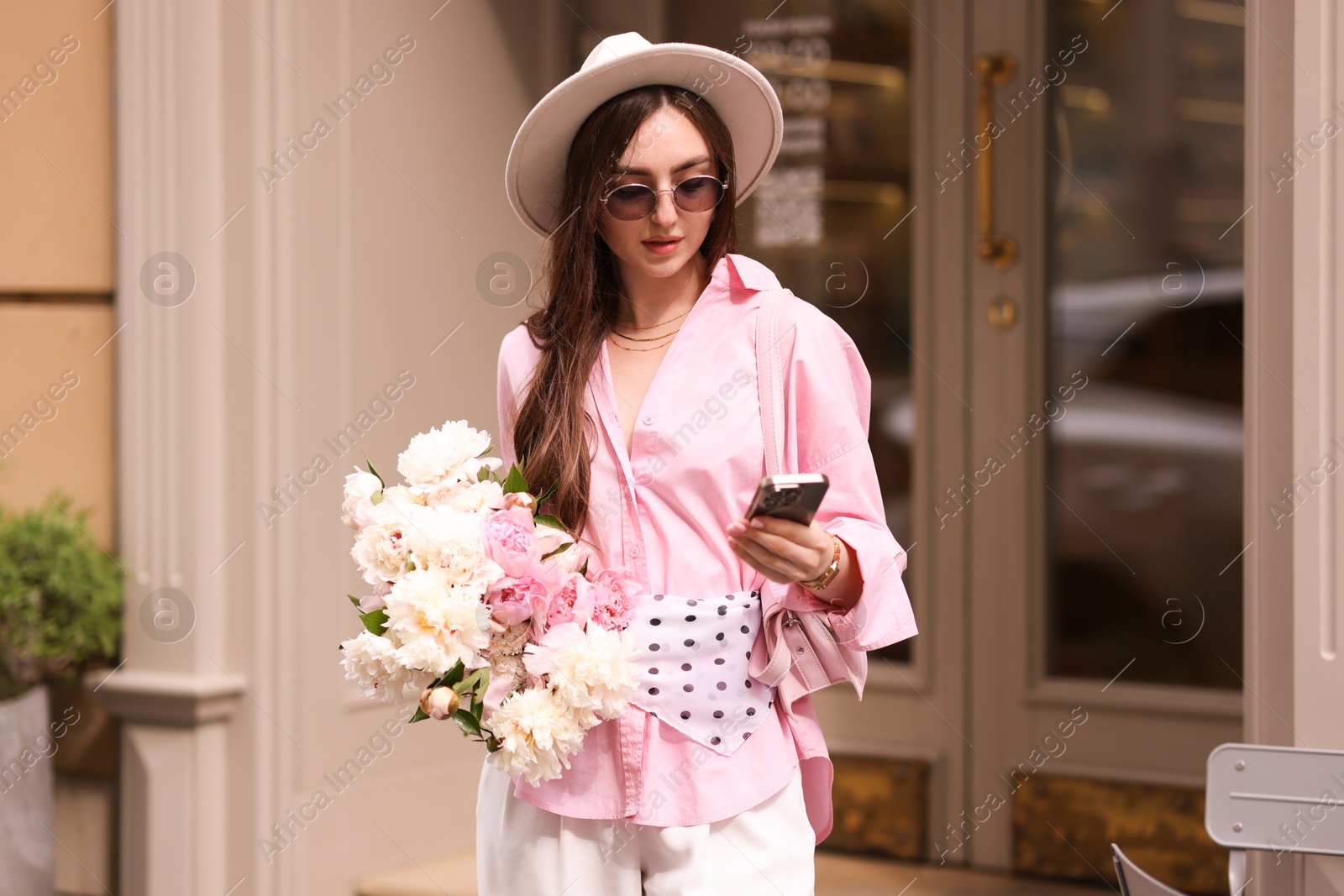 Stylish woman with bouquet of beautiful peonies and smartphone outdoors Photo of Stylish woman with bouquet of beautiful peonies and smartphone outdoors