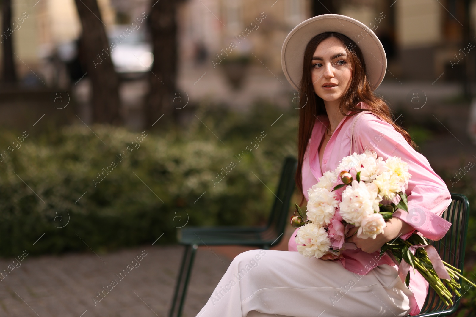 Beautiful woman with bouquet of peonies in park. Space for text Photo of Beautiful woman with bouquet of peonies in park. Space for text
