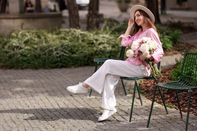 Photo of Beautiful woman with bouquet of peonies in park. Space for text