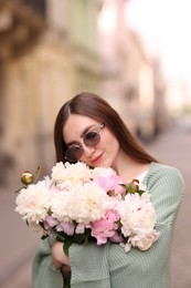 Photo of Charming woman with bouquet of beautiful peonies on city street