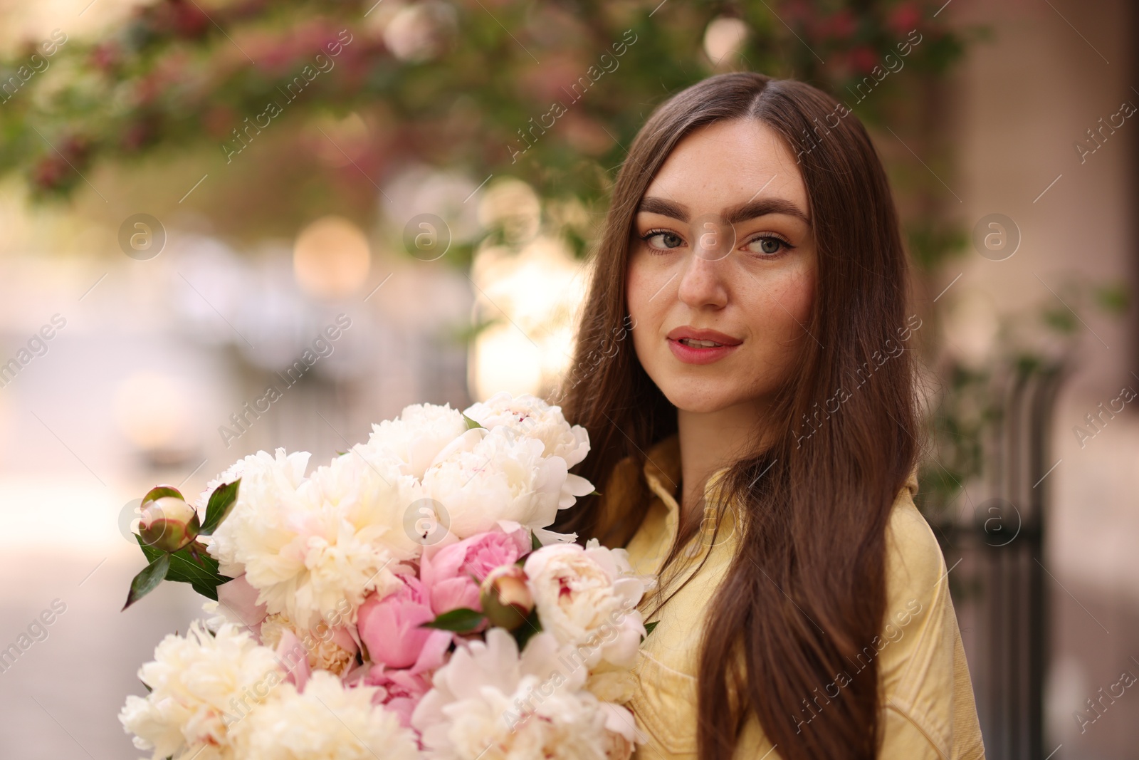 Photo of Woman with bouquet of beautiful peonies on city street