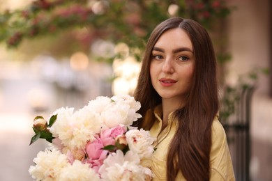 Photo of Woman with bouquet of beautiful peonies on city street