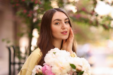 Photo of Woman with bouquet of beautiful peonies on city street