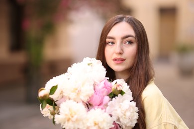 Photo of Woman with bouquet of beautiful peonies on city street