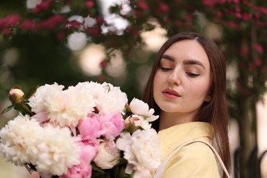 Photo of Woman with bouquet of beautiful peonies on city street