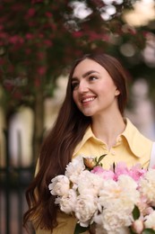 Photo of Woman with bouquet of beautiful peonies on city street
