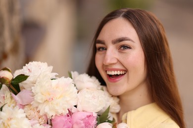 Photo of Woman with bouquet of beautiful peonies on city street
