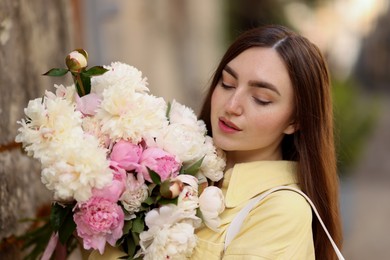 Photo of Woman with bouquet of beautiful peonies on city street