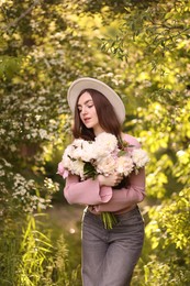 Photo of Beautiful woman with bouquet of peonies in park
