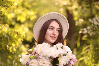 Photo of Beautiful woman with bouquet of peonies in park
