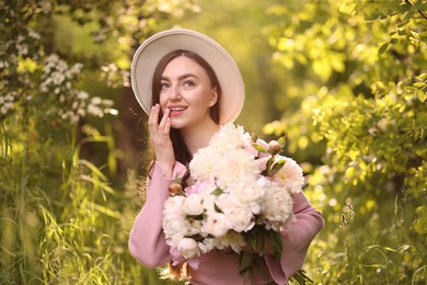 Photo of Beautiful woman with bouquet of peonies in park