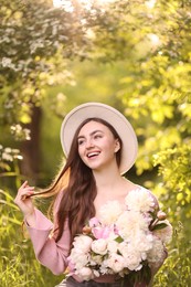 Photo of Beautiful woman with bouquet of peonies in park