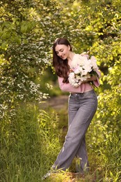 Photo of Beautiful woman with bouquet of peonies in park