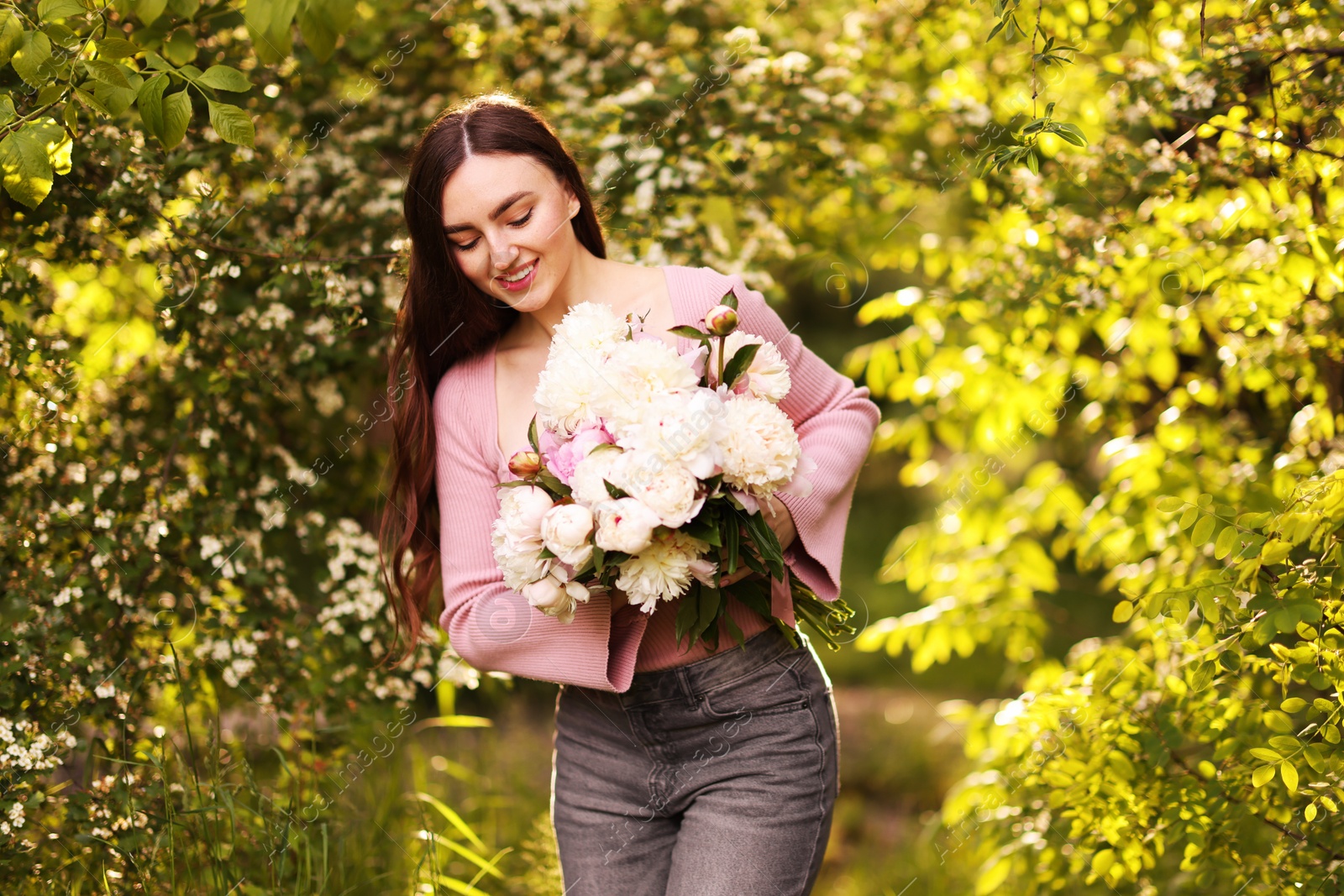 Beautiful woman with bouquet of peonies in park Photo of Beautiful woman with bouquet of peonies in park