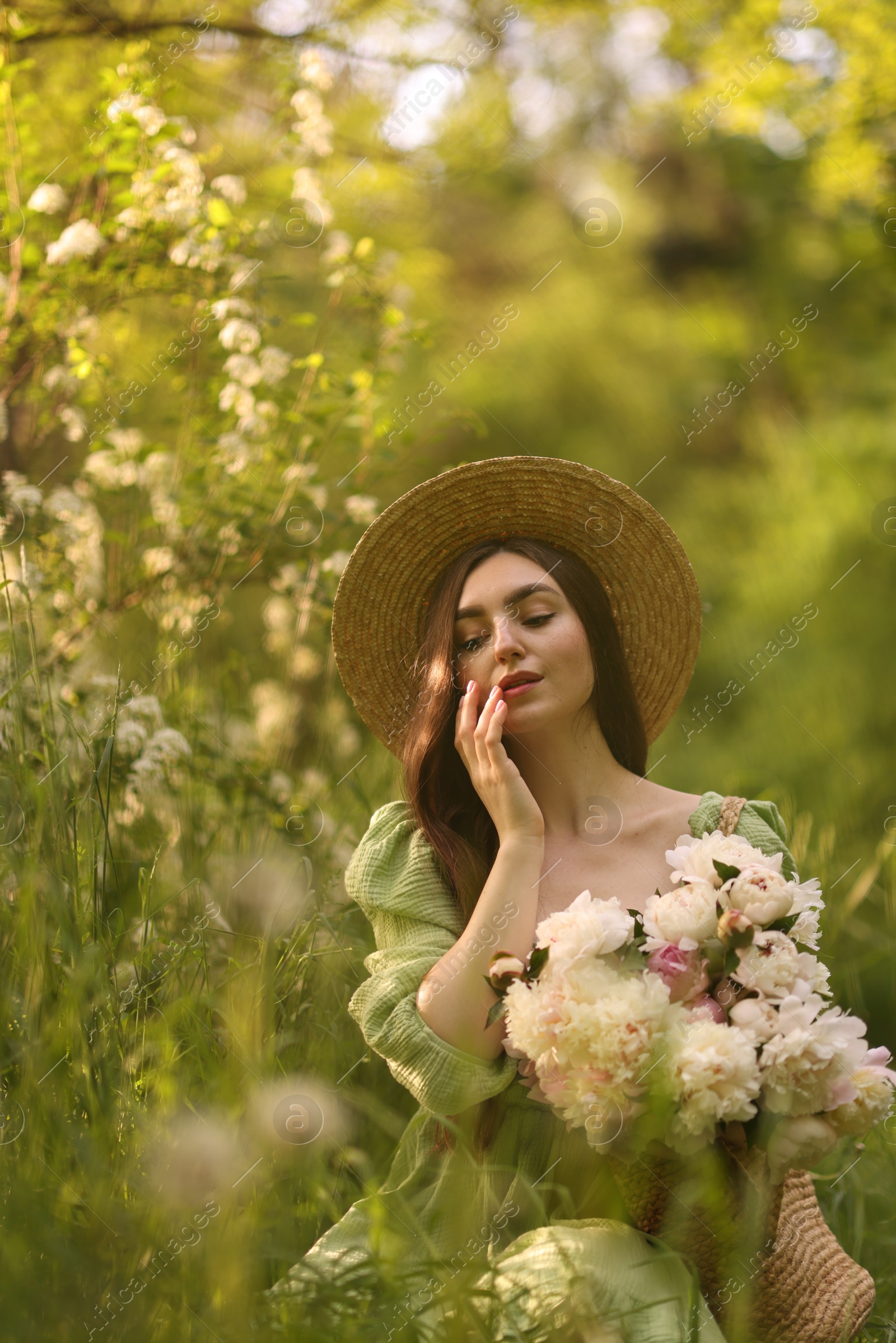 Photo of Beautiful woman with bouquet of peonies in park