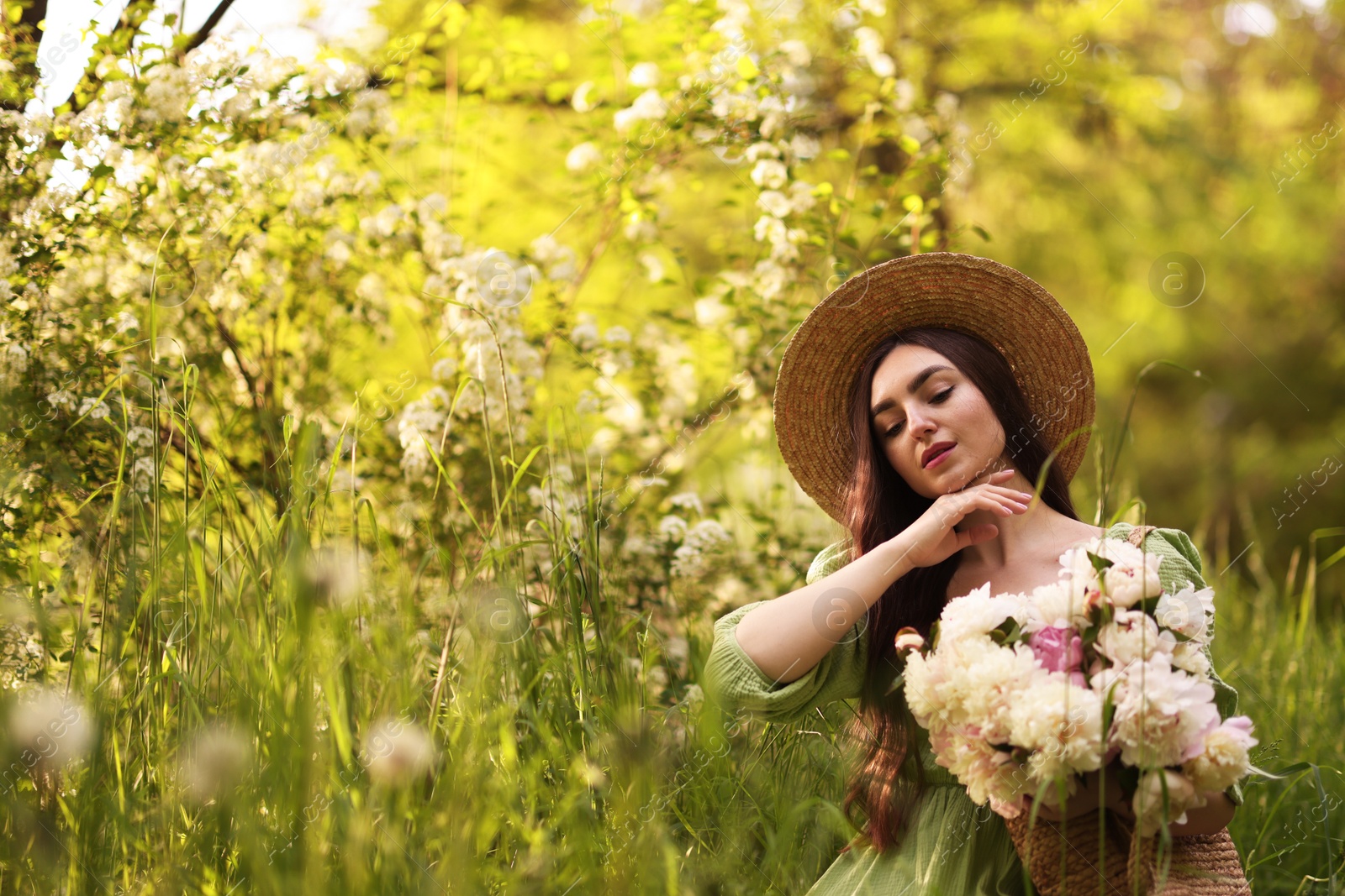 Beautiful woman with bouquet of peonies in park. Space for text Photo of Beautiful woman with bouquet of peonies in park. Space for text