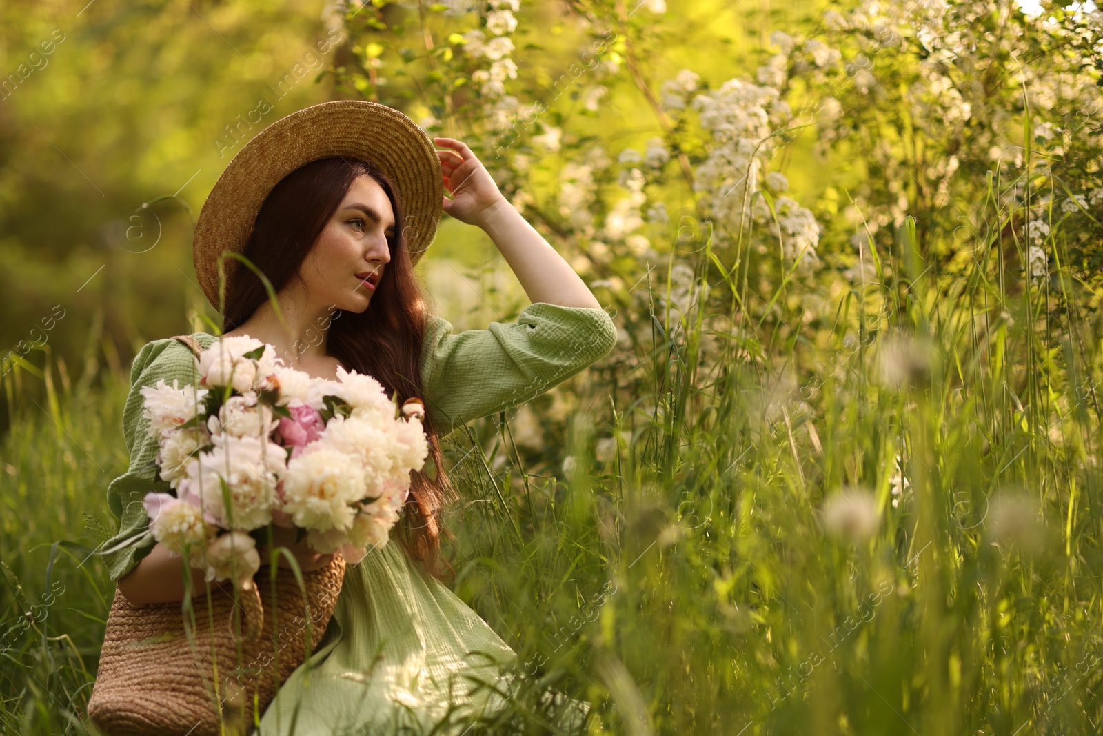Beautiful woman with bouquet of peonies in park. Space for text Photo of Beautiful woman with bouquet of peonies in park. Space for text