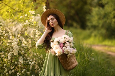 Photo of Beautiful woman with bouquet of peonies in park