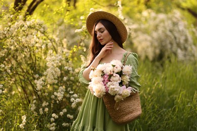 Photo of Beautiful woman with bouquet of peonies in park