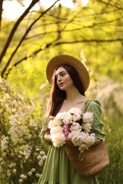 Photo of Beautiful woman with bouquet of peonies in park