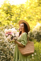Photo of Beautiful woman with bouquet of peonies in park
