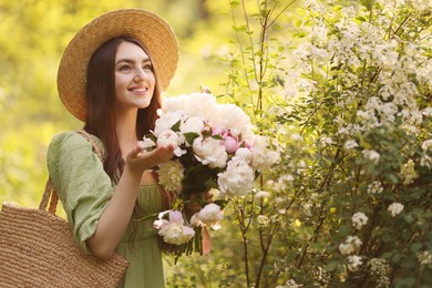 Photo of Beautiful woman with bouquet of peonies in park