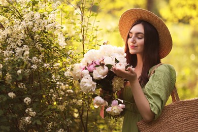 Photo of Beautiful woman with bouquet of peonies in park