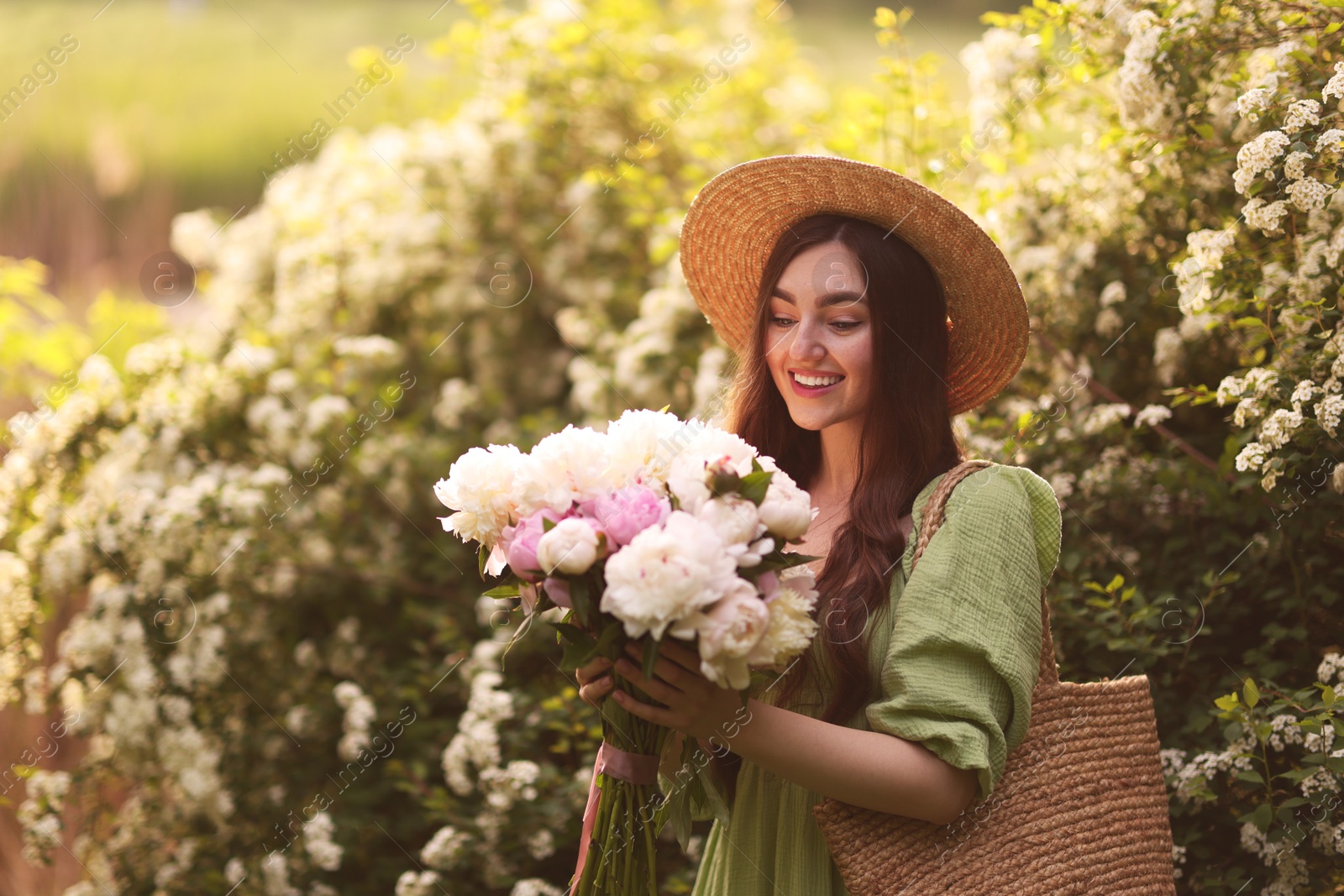 Beautiful woman with bouquet of peonies in park on sunny day. Space for text Photo of Beautiful woman with bouquet of peonies in park on sunny day. Space for text